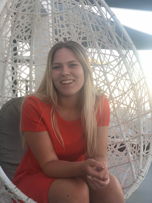 Tjej i röd klänning sitter i hängande fotölj