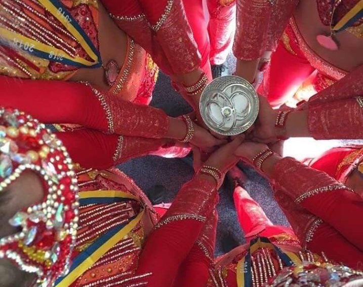 Tjejer i röda kläder håller i pokal