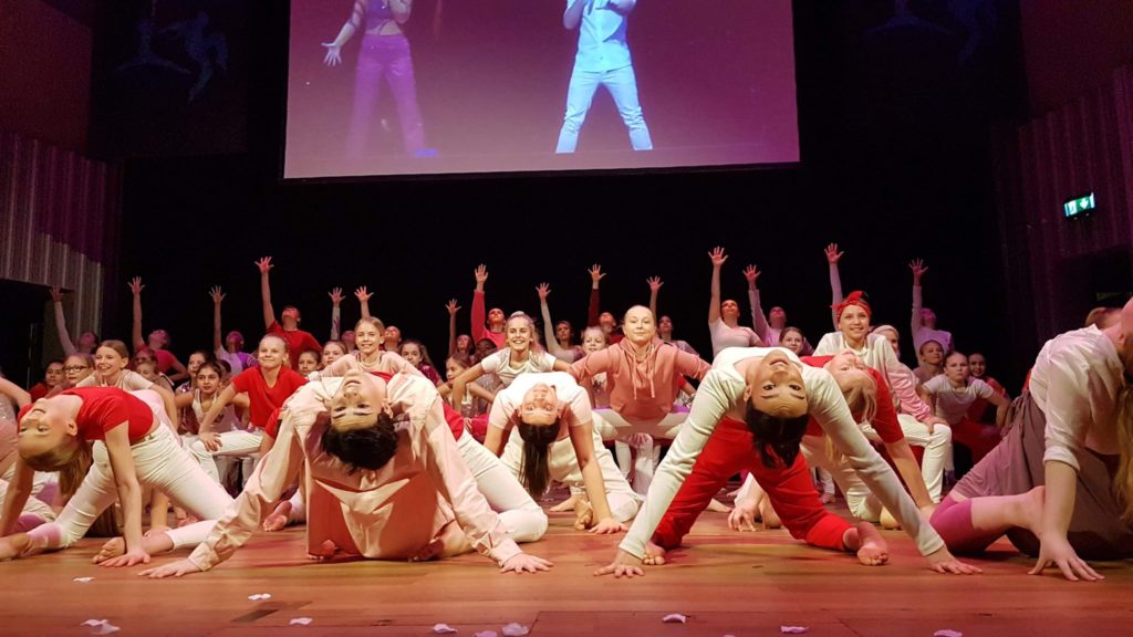 Stort gäng personer dansar på scen