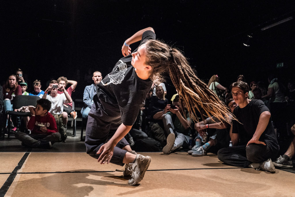 Person dansar breakdance framför publik