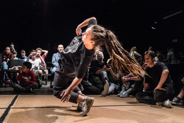 Person dansar breakdance framför publik