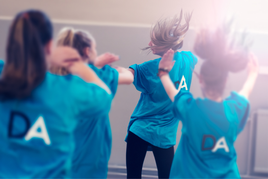 Ungdomar i blå tröjor dansar