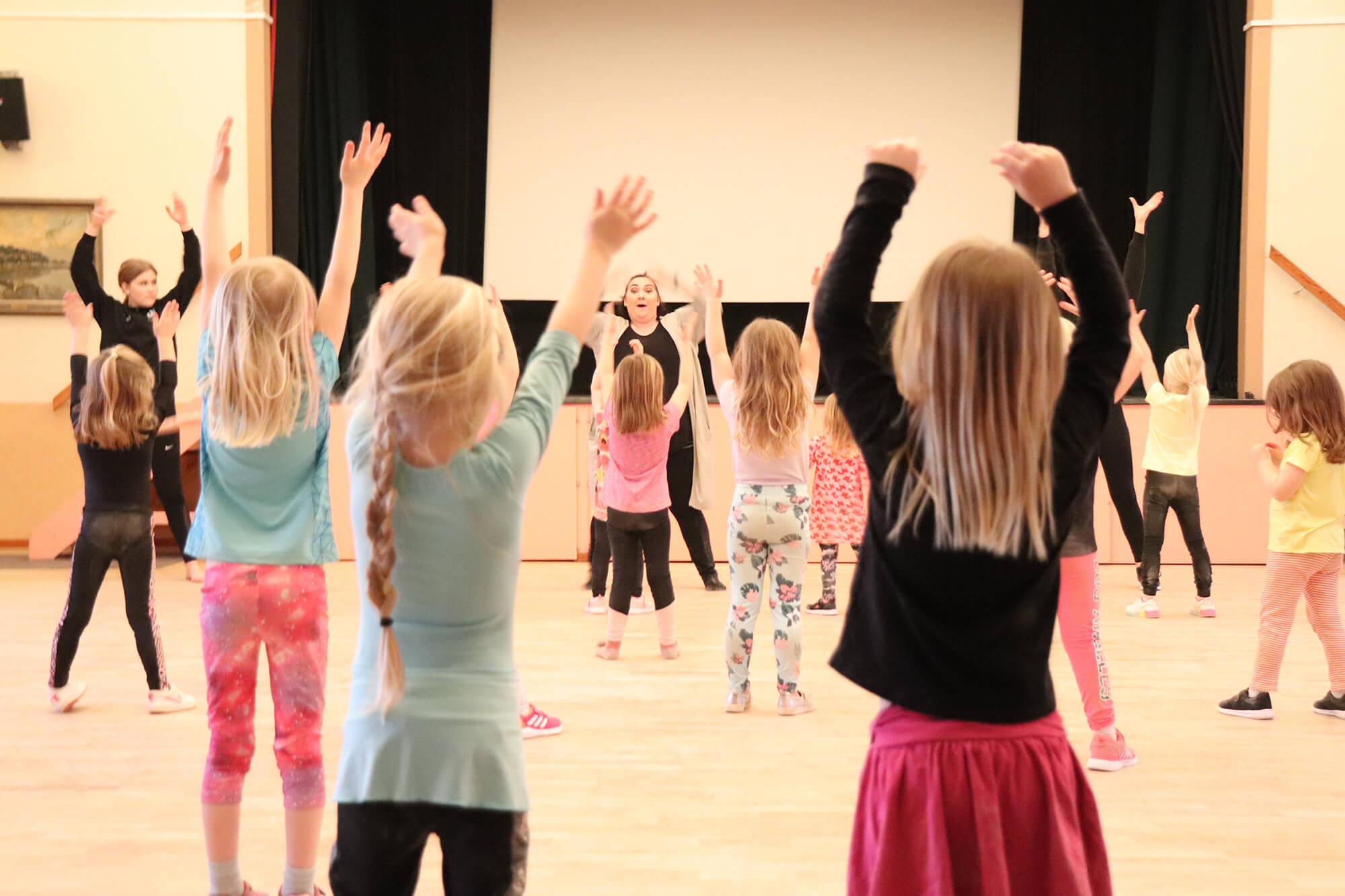 Barn dansar framför lärare